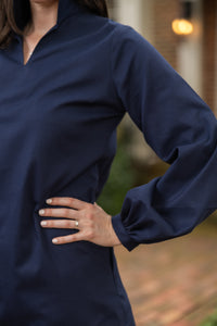 Woman wearing a classic navy dress with puffed sleeves