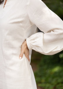 Close up of a long sleeve on a women's cream dress